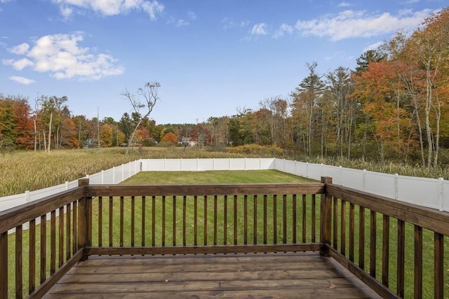 wooden terrace with a yard, a fenced backyard, and a view of trees