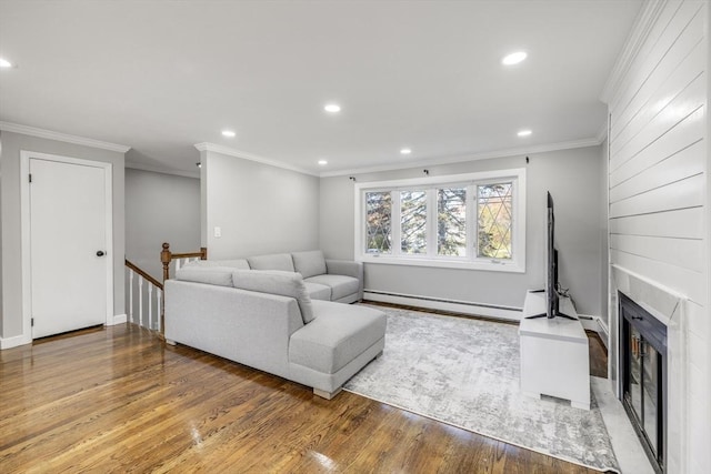 living room featuring recessed lighting, a fireplace, baseboard heating, and wood finished floors