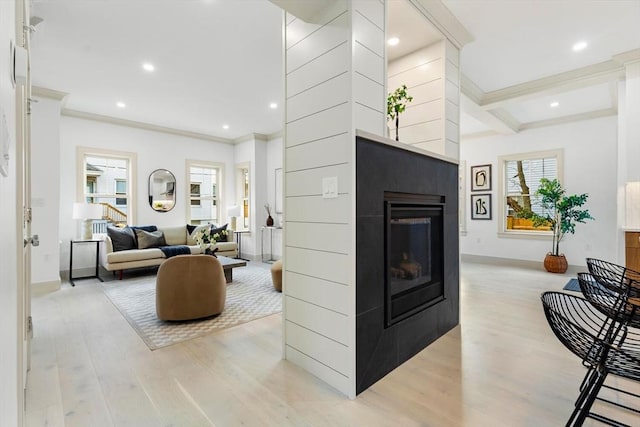 living room with beam ceiling, light hardwood / wood-style flooring, and ornamental molding