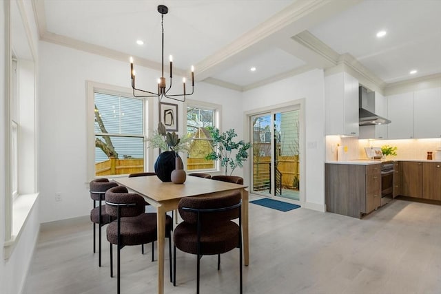 dining space with ornamental molding, light hardwood / wood-style floors, and an inviting chandelier