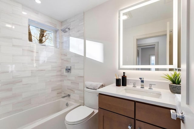 full bathroom with toilet, vanity, and tiled shower / bath