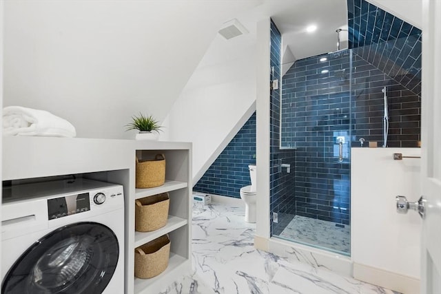 bathroom with washer / dryer, toilet, and an enclosed shower