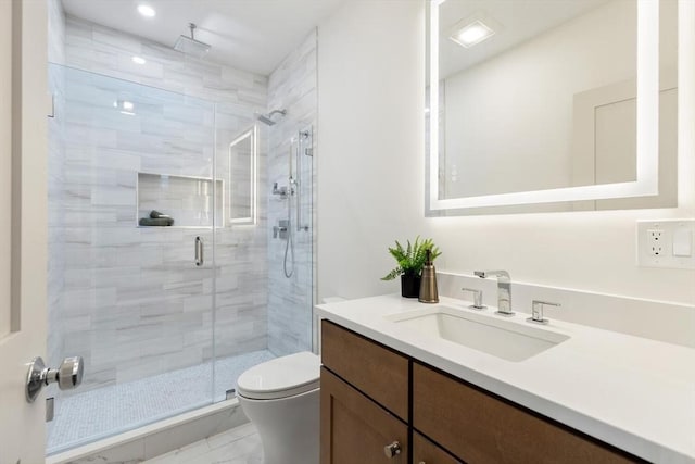 bathroom with vanity, a shower with shower door, and toilet