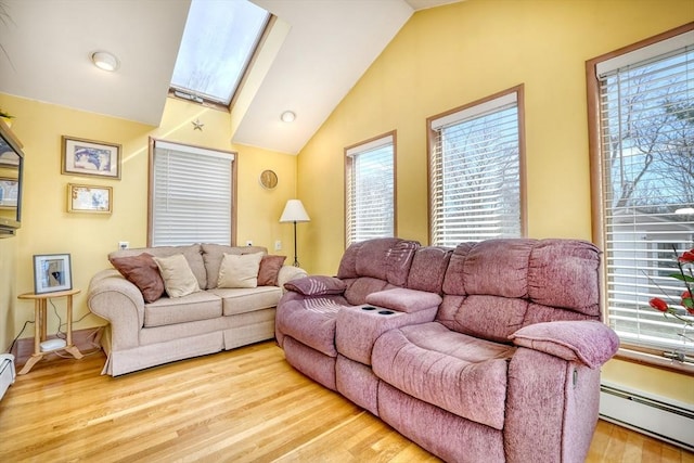 living room featuring lofted ceiling with skylight, baseboard heating, and wood finished floors