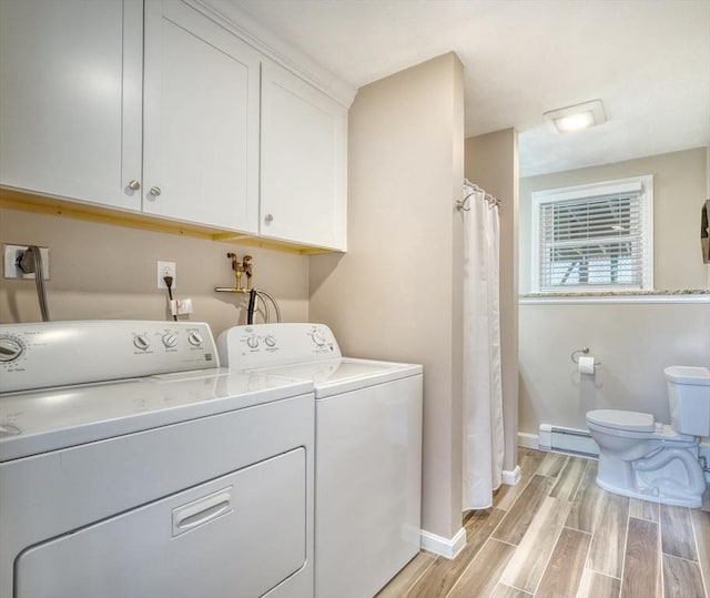 laundry room featuring laundry area, washing machine and clothes dryer, baseboard heating, and wood tiled floor