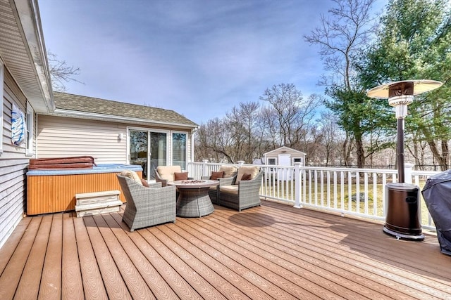 wooden terrace featuring a fire pit, an outdoor structure, and a hot tub