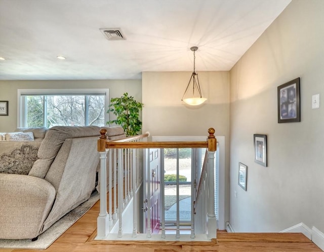 staircase featuring visible vents, baseboards, and wood finished floors