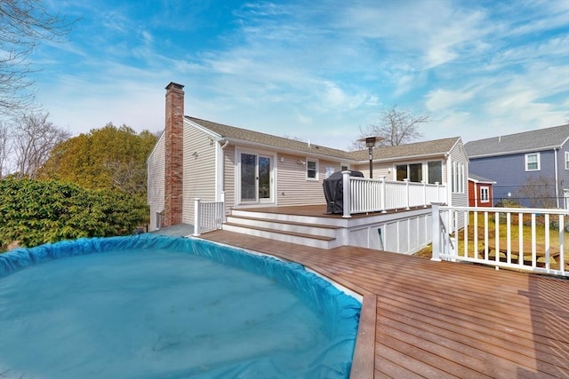 back of property with a chimney and a deck