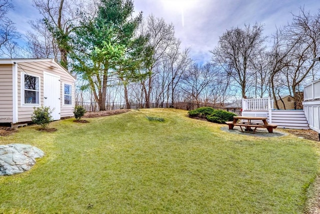 view of yard with a wooden deck, an outdoor structure, and fence