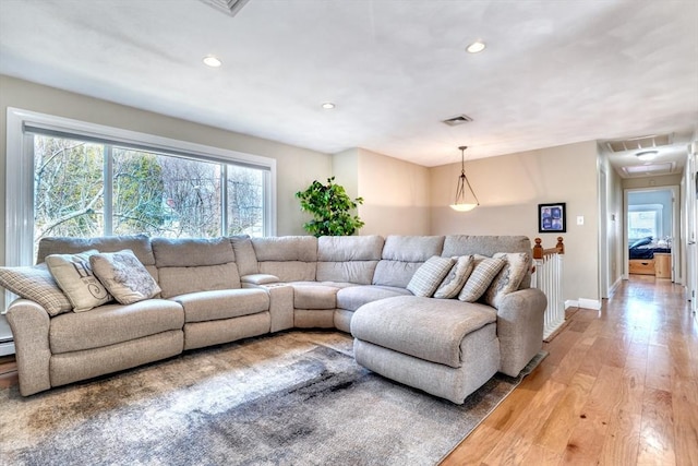 living area with recessed lighting, visible vents, attic access, and light wood finished floors