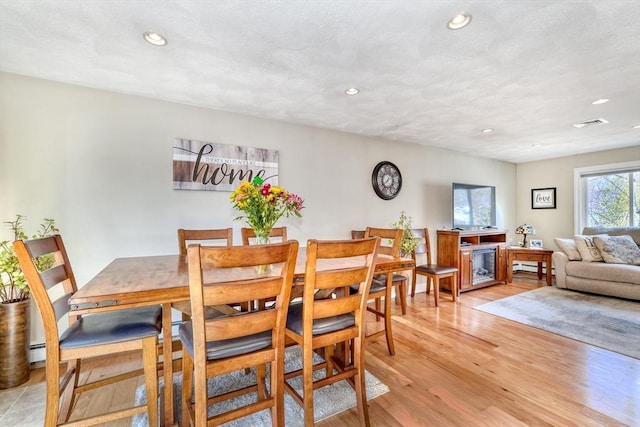 dining room with light wood-style flooring, recessed lighting, and baseboard heating