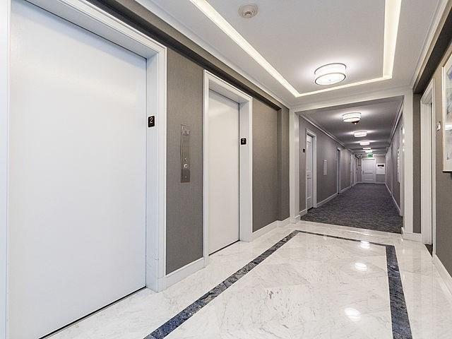 6 Whittier Pl Unit 10H, Boston, MA 02114 - hallway featuring inlaid floor details, marble tiled floors, baseboards, and elevator