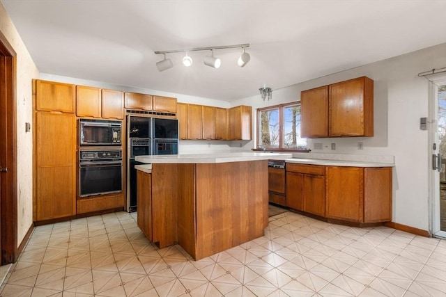 kitchen with a kitchen island, black appliances, brown cabinetry, and light countertops