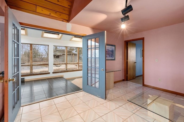 entryway with tile patterned floors, french doors, and baseboards