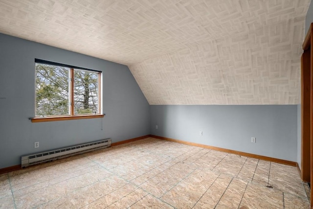 additional living space featuring a baseboard radiator, baseboards, and vaulted ceiling