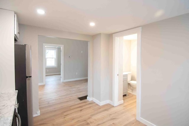 hall featuring recessed lighting, baseboards, visible vents, and light wood finished floors