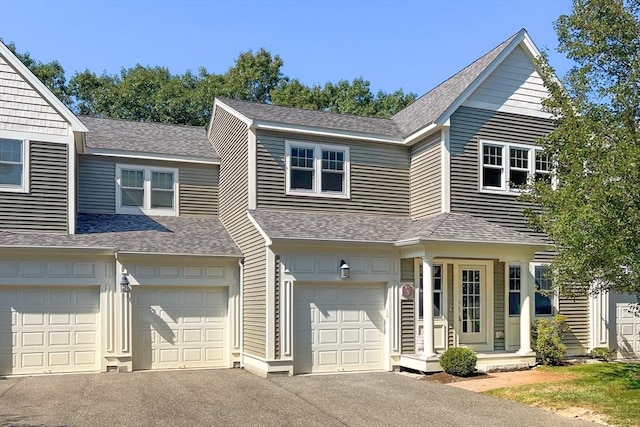 view of front of property featuring an attached garage, a shingled roof, and driveway