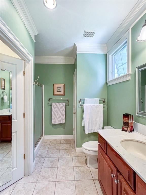 bathroom featuring visible vents, ornamental molding, a shower stall, vanity, and tile patterned flooring