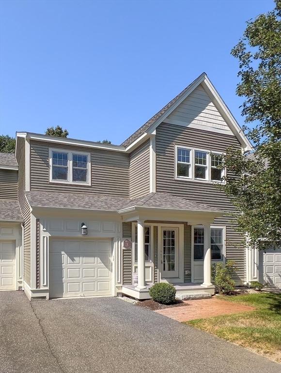 view of front of property with a porch, an attached garage, a shingled roof, and aphalt driveway
