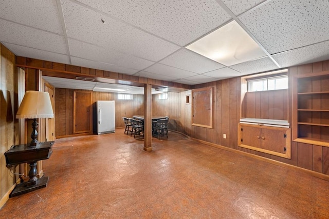 301 Main St, Acushnet, MA 02743 - basement featuring wooden walls, a drop ceiling, freestanding refrigerator, and baseboards