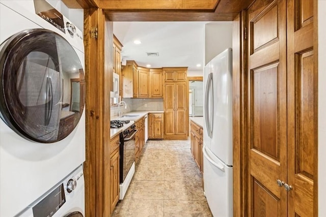 16 River Rd, Hanover, MA 02339 - kitchen featuring freestanding refrigerator, gas stove, stacked washer / dryer, light countertops, and tasteful backsplash