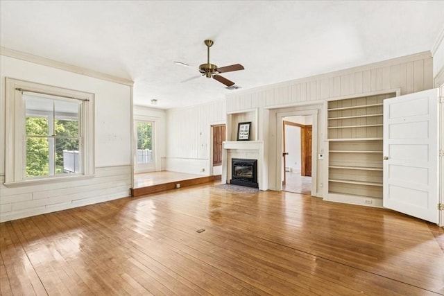 16 River Rd, Hanover, MA 02339 - unfurnished living room featuring crown molding, hardwood / wood-style floors, ceiling fan, a fireplace with flush hearth, and wood walls