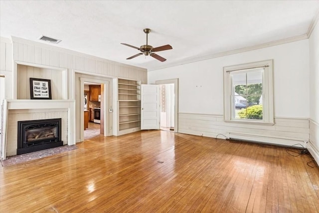 16 River Rd, Hanover, MA 02339 - unfurnished living room featuring light wood-style floors, ornamental molding, ceiling fan, a fireplace with flush hearth, and a wainscoted wall