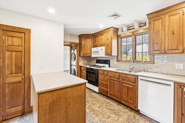16 River Rd, Hanover, MA 02339 - kitchen featuring white appliances, stacked washer / dryer, a peninsula, decorative backsplash, and light countertops