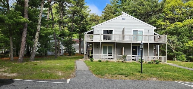 70 Cape Dr Unit 12C, Mashpee, MA 02649 - view of front of house featuring a porch, a front lawn, and view of wooded area