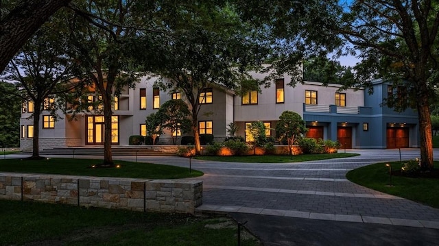 view of front of property featuring curved driveway and stucco siding