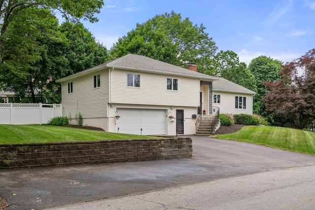 5 Cutler Rd, Paxton, MA 01612 - split level home featuring a chimney, asphalt driveway, and a garage