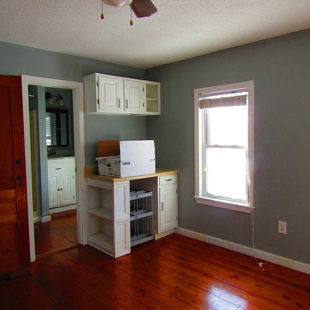 kitchen featuring dark hardwood / wood-style flooring, ceiling fan, and white cabinets