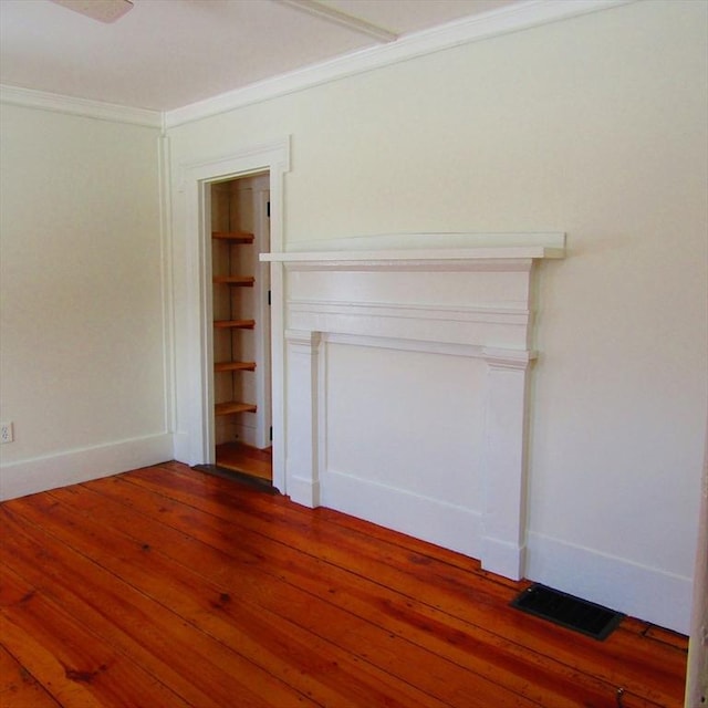 spare room with ornamental molding and dark hardwood / wood-style flooring