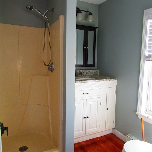 bathroom featuring walk in shower, vanity, toilet, and hardwood / wood-style floors