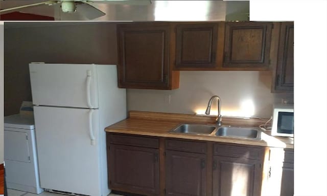 kitchen with washer / clothes dryer, sink, white fridge, ceiling fan, and dark brown cabinets