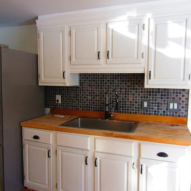 kitchen featuring sink, white cabinets, and decorative backsplash