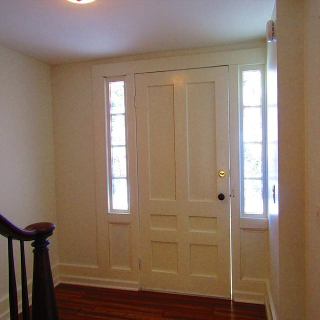 foyer entrance featuring plenty of natural light and dark hardwood / wood-style floors