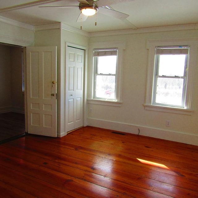 unfurnished bedroom featuring hardwood / wood-style flooring, ceiling fan, and crown molding