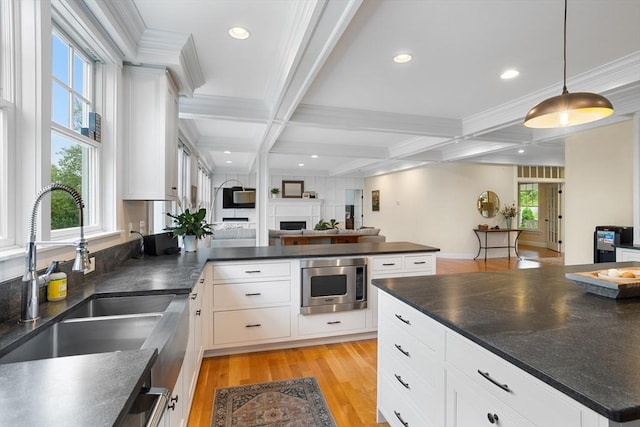 81 Hanover Rd, Carlisle, MA 01741 - kitchen with a sink, stainless steel microwave, dark countertops, a peninsula, and beamed ceiling