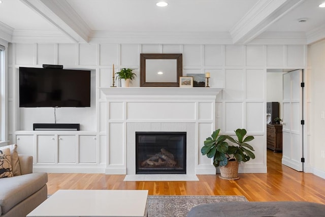 81 Hanover Rd, Carlisle, MA 01741 - living room featuring ornamental molding, a decorative wall, light wood finished floors, beam ceiling, and a fireplace with flush hearth