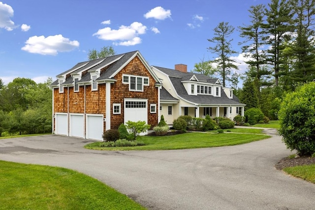 81 Hanover Rd, Carlisle, MA 01741 - view of front of house with asphalt driveway, a garage, a chimney, a front lawn, and a shingled roof