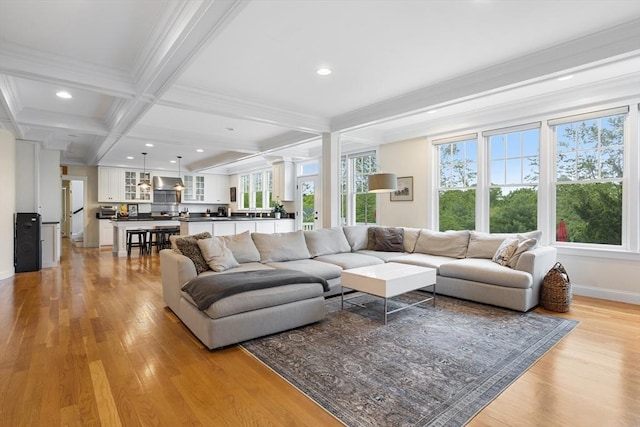 81 Hanover Rd, Carlisle, MA 01741 - living room with light wood-type flooring, ornamental molding, beam ceiling, baseboards, and recessed lighting