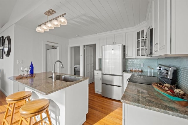 kitchen featuring dark stone countertops, white cabinetry, sink, and appliances with stainless steel finishes