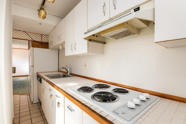 kitchen featuring white appliances, white cabinets, tile countertops, under cabinet range hood, and a sink