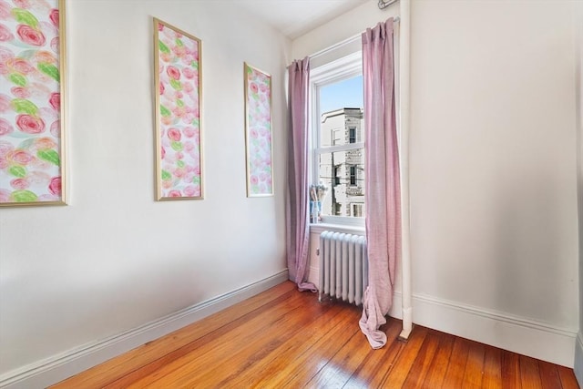 spare room with radiator heating unit and light hardwood / wood-style floors