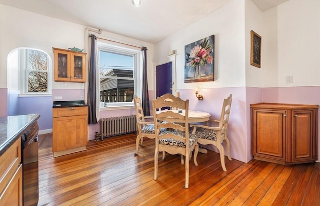 dining space with radiator heating unit and hardwood / wood-style floors