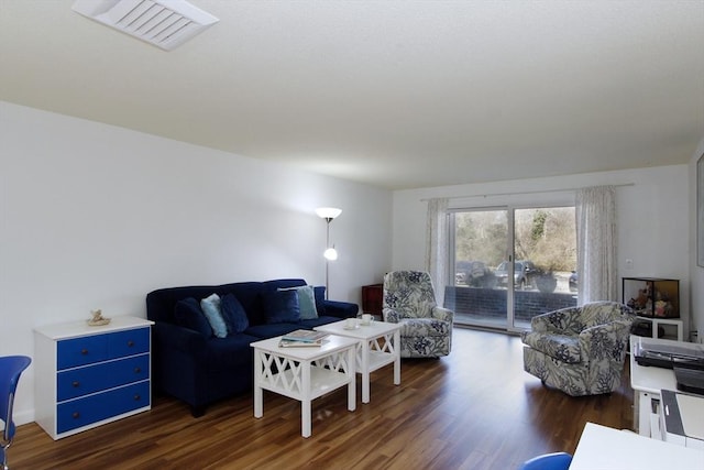 living area featuring dark wood-type flooring and visible vents