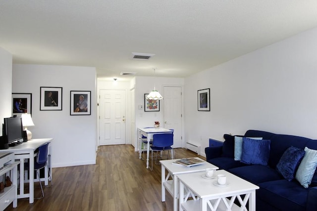 living area with visible vents, a baseboard radiator, baseboards, and dark wood finished floors