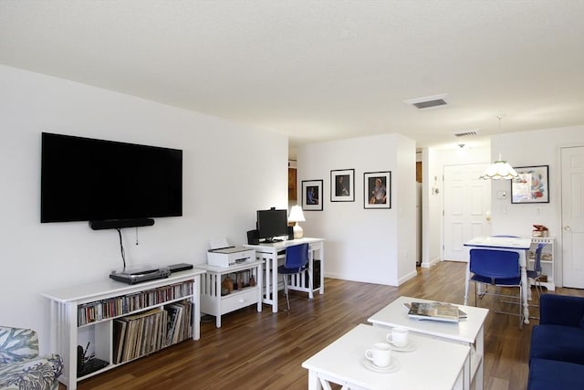 living room with dark wood-style flooring, baseboards, and visible vents