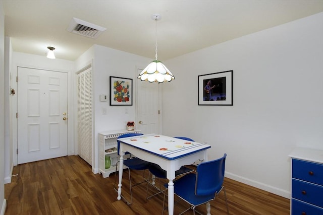 dining space with visible vents, baseboards, and wood finished floors